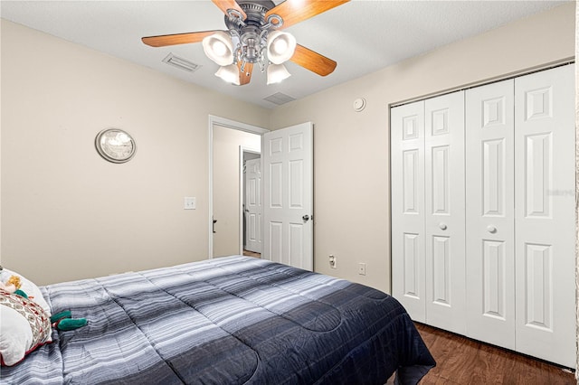 bedroom featuring dark hardwood / wood-style flooring, a closet, and ceiling fan