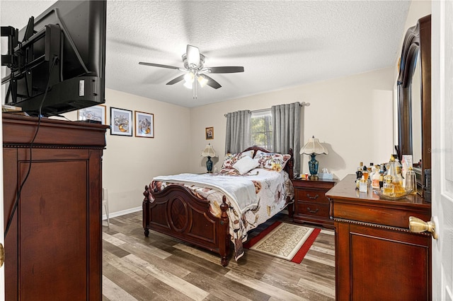 bedroom featuring ceiling fan, a textured ceiling, and light wood-type flooring