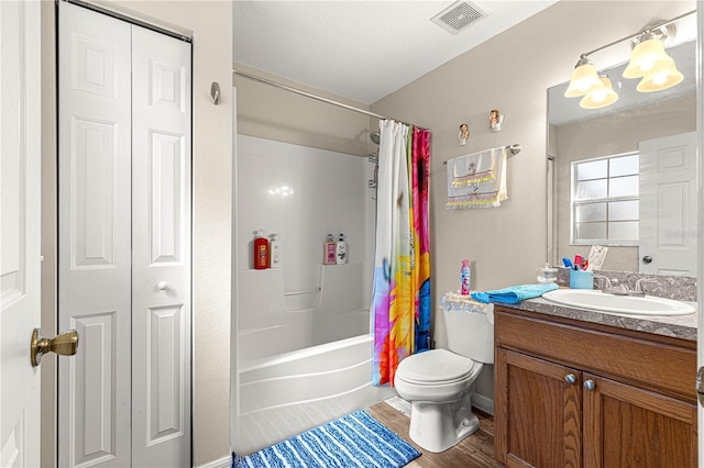 full bathroom with hardwood / wood-style flooring, shower / bath combo, vanity, a notable chandelier, and toilet