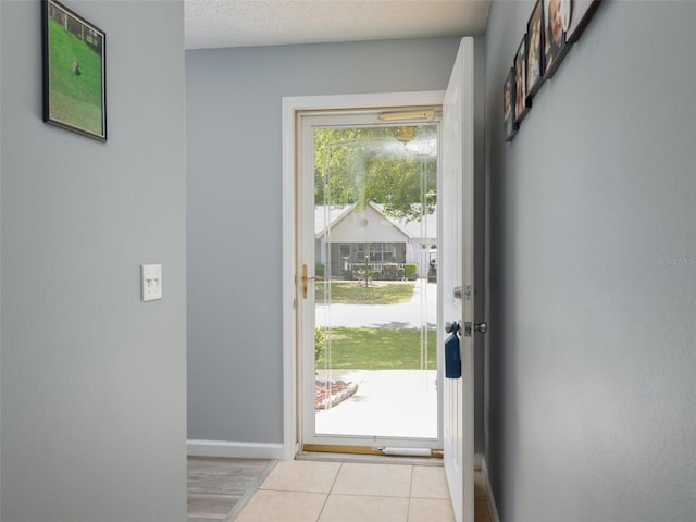 entryway with light hardwood / wood-style floors and a textured ceiling