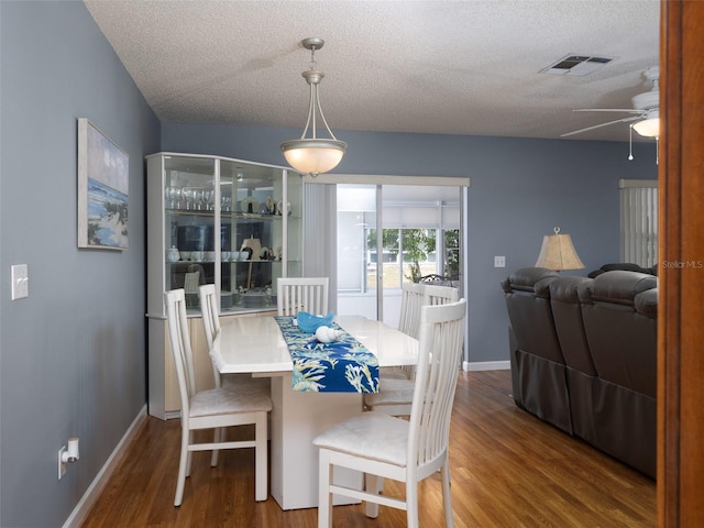 dining space with a textured ceiling, ceiling fan, and hardwood / wood-style flooring