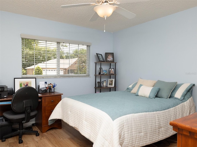 bedroom featuring a textured ceiling, ceiling fan, and light hardwood / wood-style floors