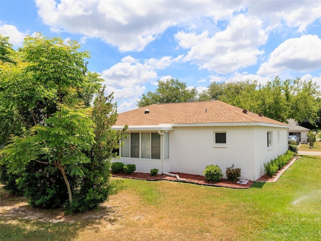 rear view of house featuring a lawn