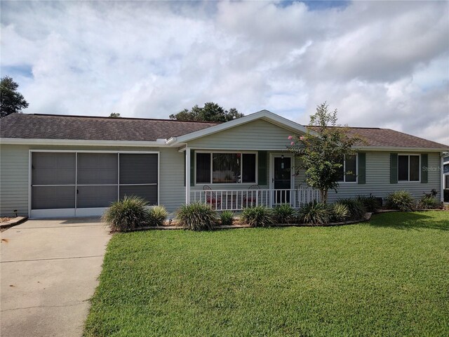 ranch-style home with a porch, a front yard, and a garage