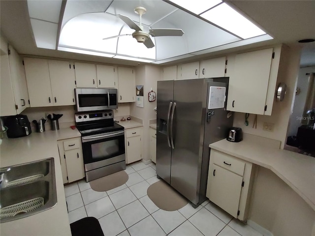 kitchen featuring light tile patterned floors, stainless steel appliances, light countertops, and ceiling fan