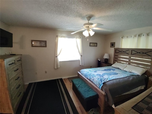 bedroom featuring ceiling fan, wood finished floors, baseboards, and a textured ceiling