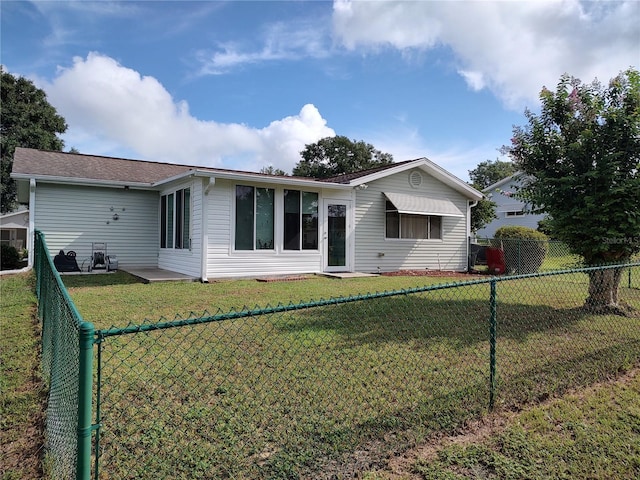 back of house with a lawn and a fenced backyard