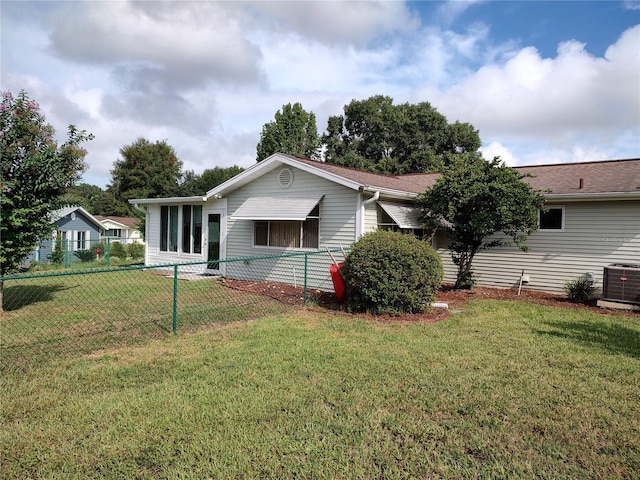 ranch-style home with central air condition unit, fence private yard, and a front yard