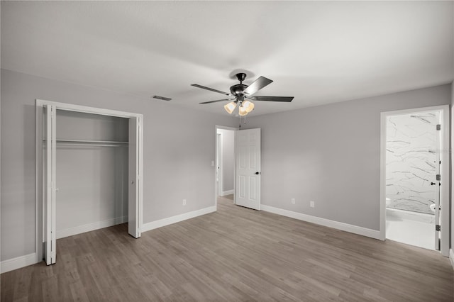 unfurnished bedroom featuring a closet, ensuite bath, ceiling fan, and light hardwood / wood-style flooring