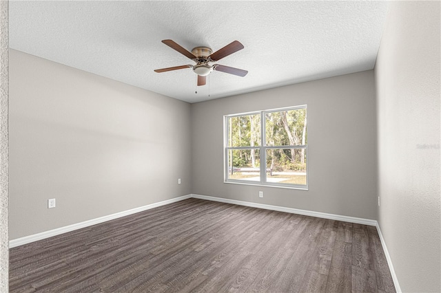 empty room featuring ceiling fan, dark wood-type flooring, and a textured ceiling