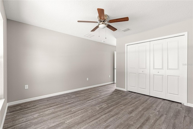 unfurnished bedroom featuring hardwood / wood-style flooring, ceiling fan, a closet, and a textured ceiling