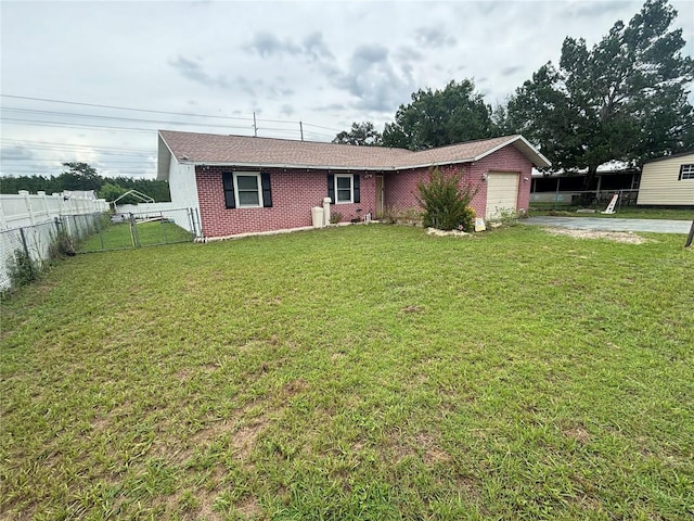 view of front of house featuring a front yard, fence, driveway, a garage, and brick siding