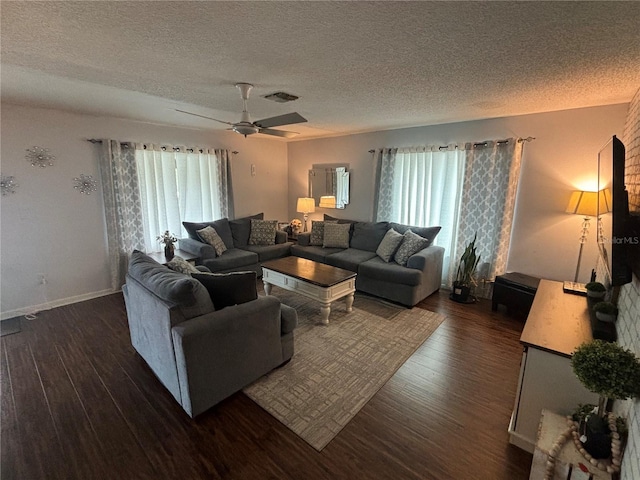 living area featuring visible vents, a textured ceiling, and dark wood-type flooring