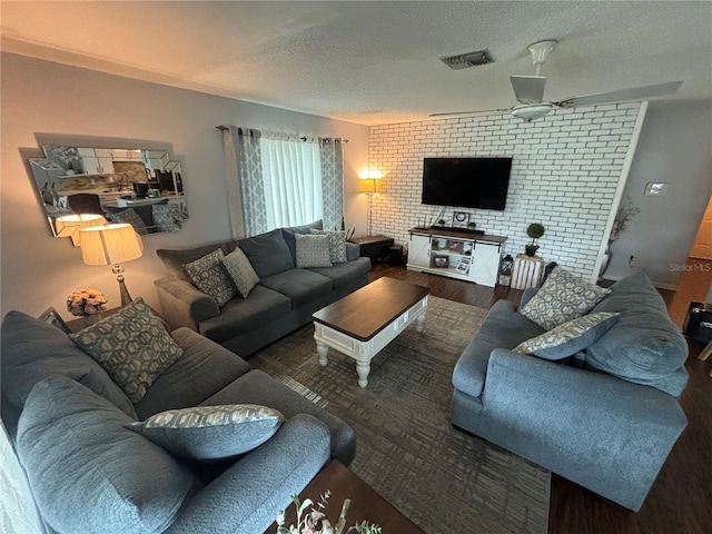 living room with a textured ceiling and dark hardwood / wood-style floors