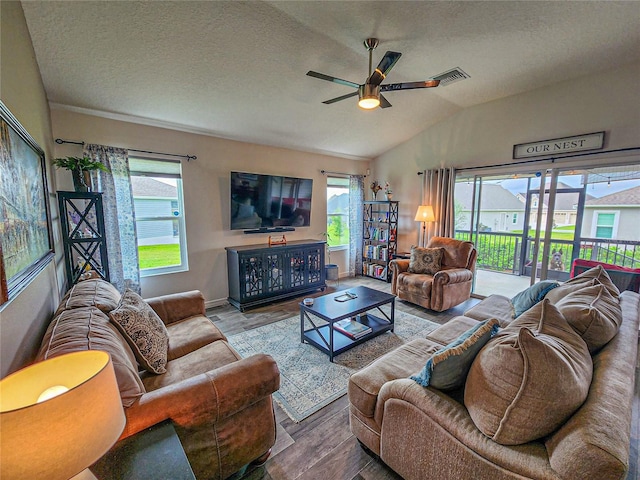 living room featuring wood-type flooring, a textured ceiling, ceiling fan, and lofted ceiling