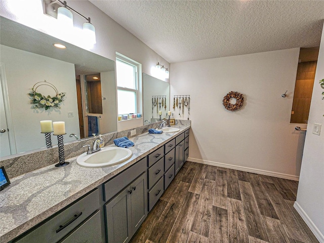 bathroom with vanity, wood-type flooring, and a textured ceiling