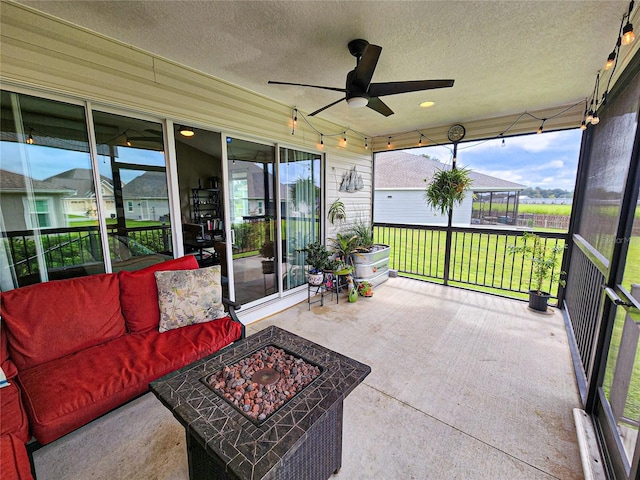 sunroom featuring ceiling fan and plenty of natural light