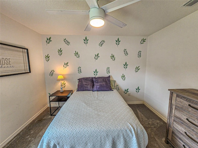 bedroom featuring a textured ceiling, dark carpet, and ceiling fan