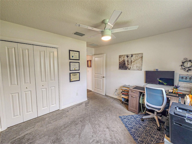 carpeted office with a textured ceiling and ceiling fan