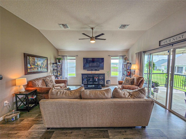 living room featuring a textured ceiling, dark hardwood / wood-style floors, vaulted ceiling, and ceiling fan