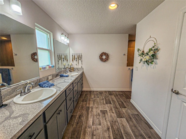 bathroom with vanity, a textured ceiling, and hardwood / wood-style flooring