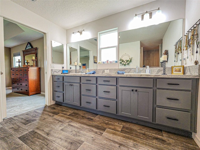 bathroom with hardwood / wood-style floors, vanity, and a textured ceiling