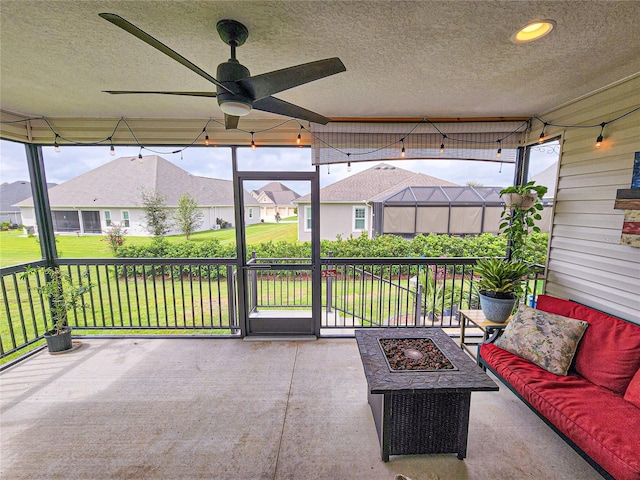 unfurnished sunroom with ceiling fan