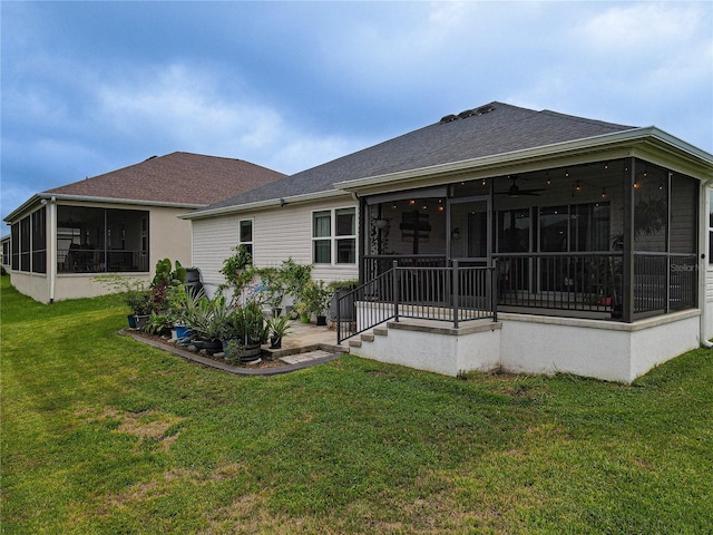 back of house featuring a lawn and a sunroom