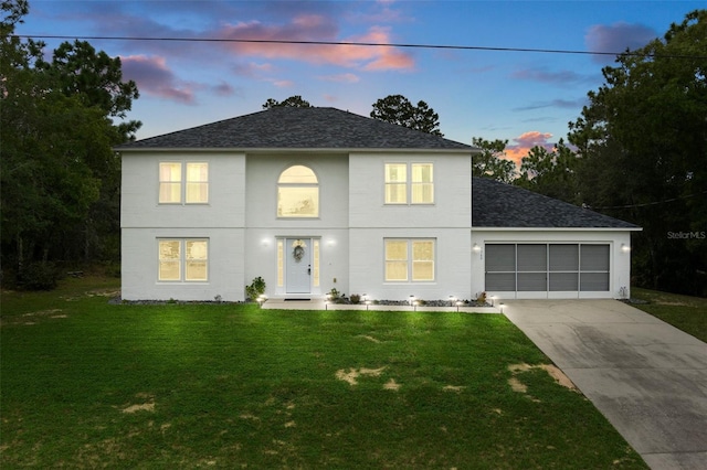 view of front of house featuring a yard and a garage