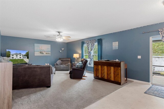 carpeted living room featuring a textured ceiling, plenty of natural light, and ceiling fan