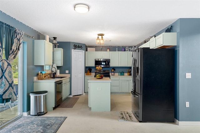 kitchen with appliances with stainless steel finishes, a kitchen island, a textured ceiling, and sink