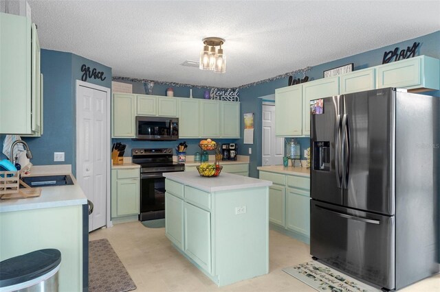 kitchen with a textured ceiling, green cabinetry, a kitchen island, sink, and appliances with stainless steel finishes