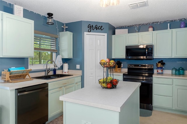 kitchen featuring a textured ceiling, a kitchen island, sink, and appliances with stainless steel finishes