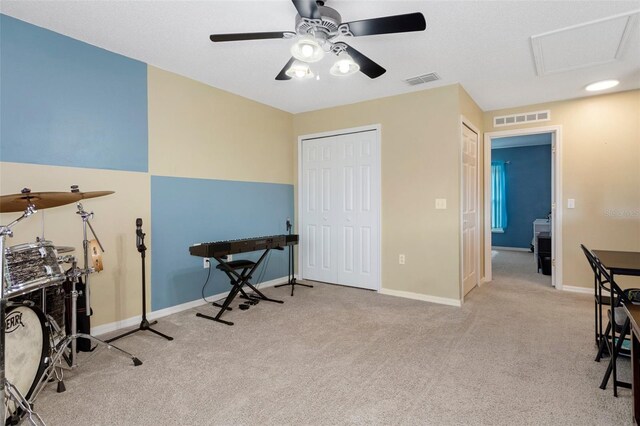 misc room with light colored carpet and ceiling fan