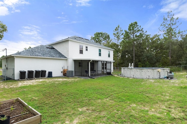 rear view of property with a fenced in pool, central air condition unit, a lawn, and a sunroom