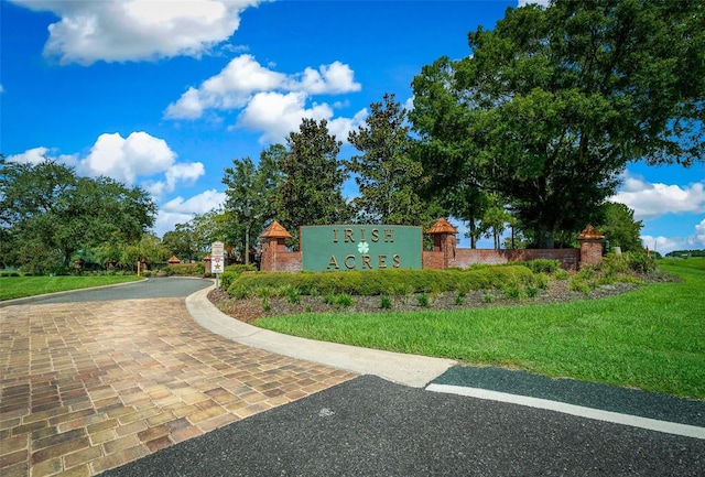 community / neighborhood sign featuring a yard