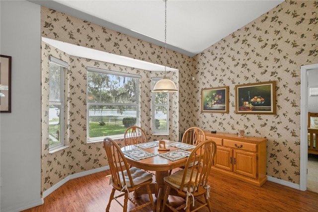 dining area with vaulted ceiling and hardwood / wood-style flooring