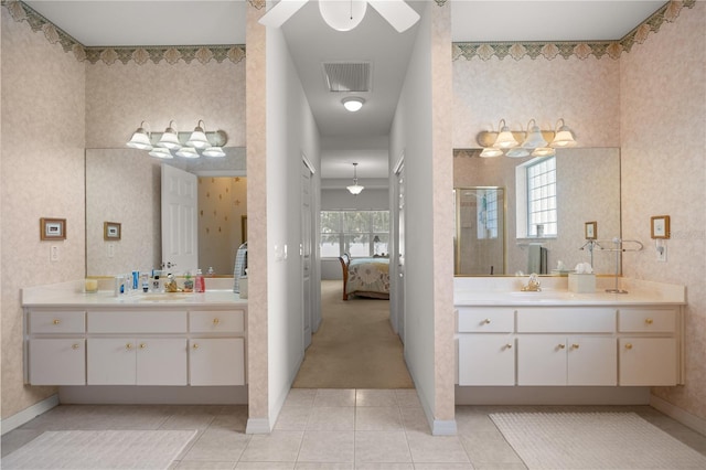 bathroom with tile patterned floors, a shower with door, plenty of natural light, and vanity