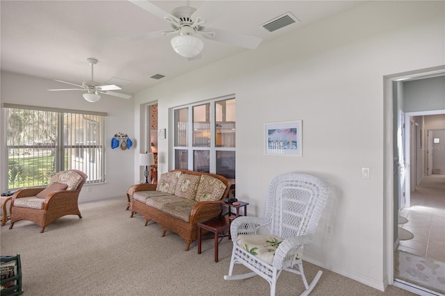 living area with ceiling fan and light carpet