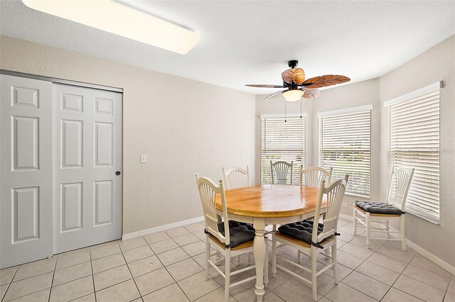 tiled dining area featuring ceiling fan and a textured ceiling