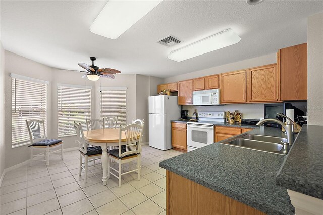 kitchen with white appliances, a textured ceiling, light tile patterned floors, sink, and ceiling fan