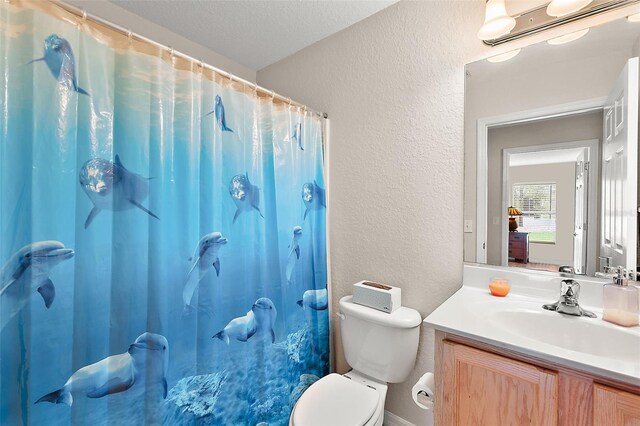 bathroom with a shower with curtain, toilet, a textured ceiling, and vanity