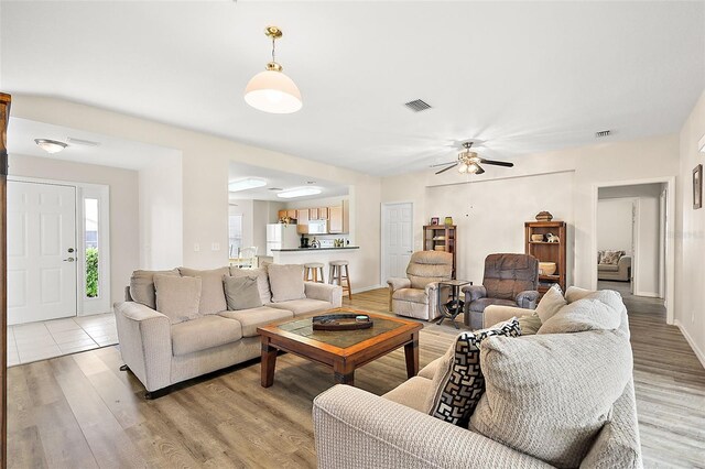 living room with ceiling fan and light wood-type flooring