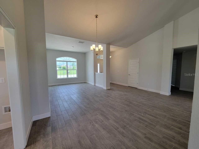 spare room with visible vents, baseboards, dark wood finished floors, an inviting chandelier, and high vaulted ceiling