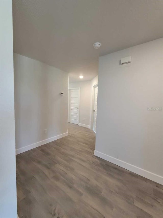 spare room featuring wood finished floors and baseboards