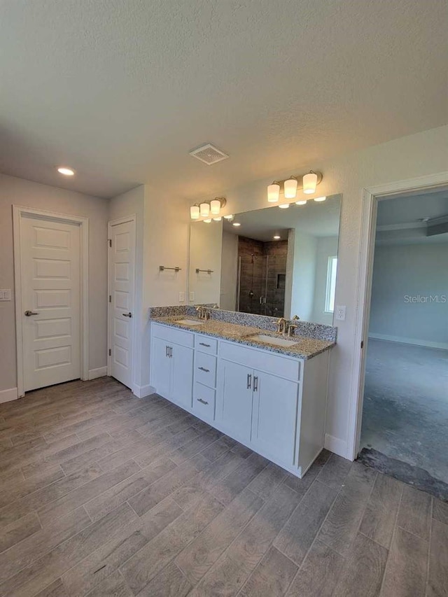 bathroom featuring visible vents, wood finished floors, and a stall shower