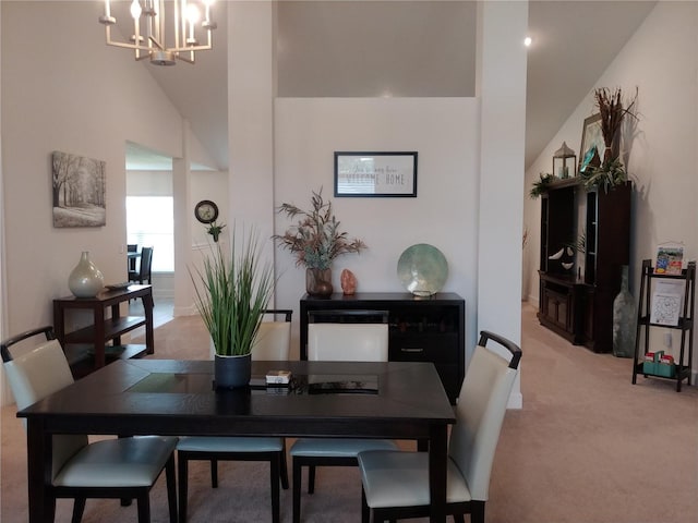 dining room featuring light carpet and a chandelier