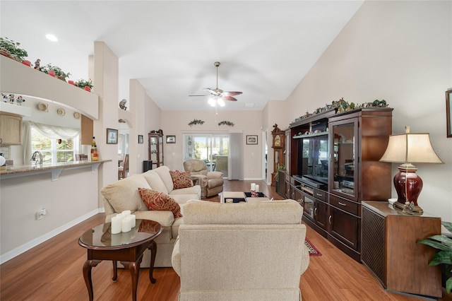 living room featuring a wealth of natural light, ceiling fan, and light wood-type flooring