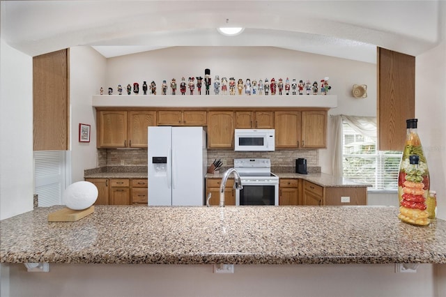 kitchen featuring white appliances, backsplash, kitchen peninsula, lofted ceiling, and light stone counters