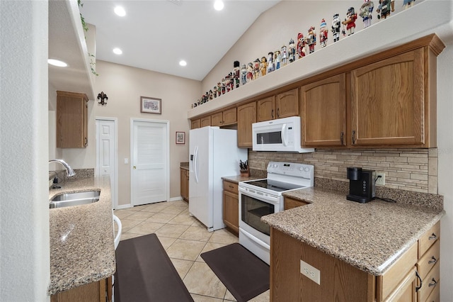 kitchen with backsplash, white appliances, light stone counters, sink, and lofted ceiling